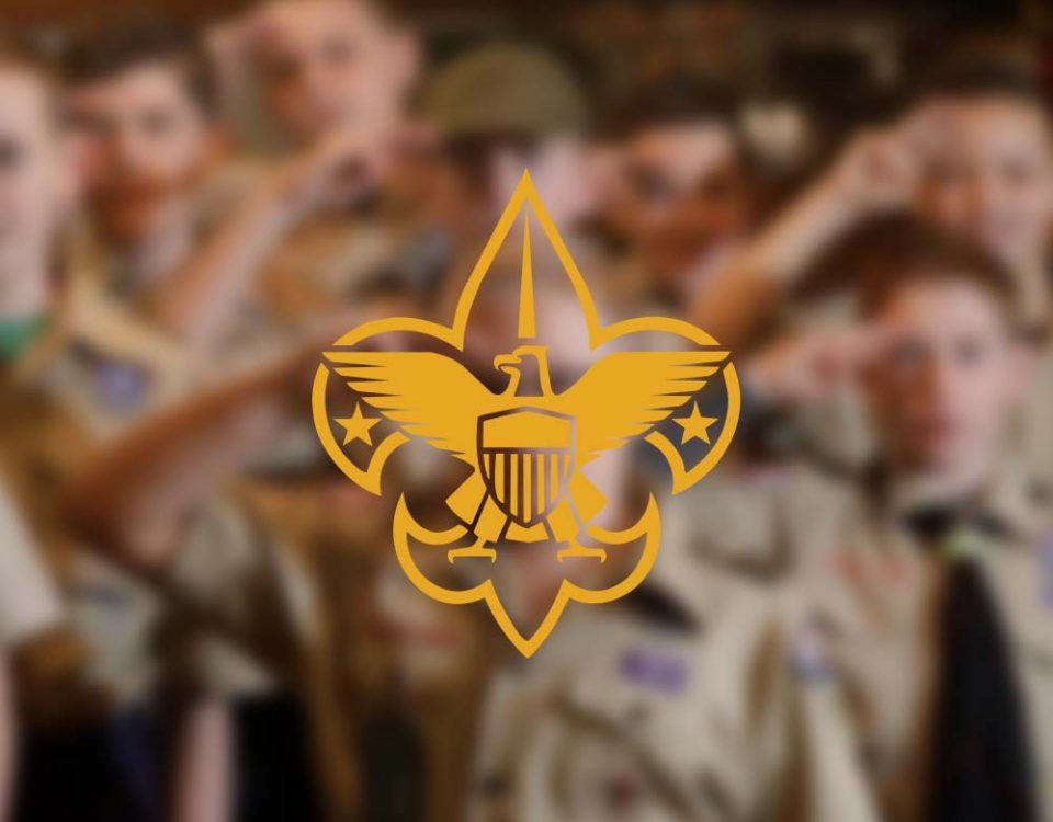 The Boy Scout logo over a blurred out photograph of Boy Scouts saluting in the background.